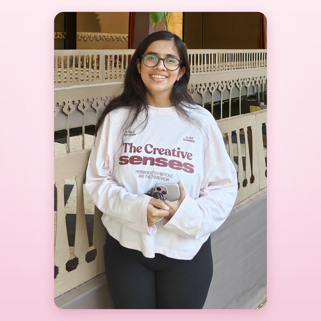 Prachi, smiling, in a pale pink sweatshirt